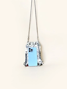 Detail view of silver sequin mini crossbody bag showing size with a smartphone