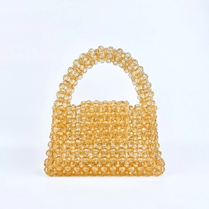 Détail d'un sac à main artisanal en perles ambrées avec texture cristal brillante