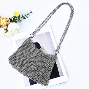 Detailed close-up of silver chainmail crossbody bag with shiny metallic sequins and chain