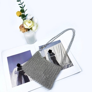 Macro shot of silver metal chainmail texture and woven sequin pattern on a luxury bag