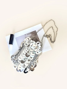 Macro shot of silver sequin fish scale texture on a chic evening crossbody bag