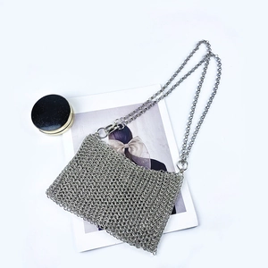 Detailed view of silver metal mesh chain bag with intricate woven sequins and shiny finish