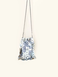 Detailed view of silver sequin bag with metallic discs and chain link texture