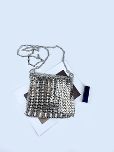Macro shot of silver metal mesh texture and wavy scale pattern on luxurious evening bag