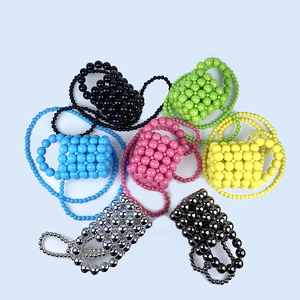 Flat lay of colorful handmade beaded mini bucket bags in seven vibrant pearl-like finishes