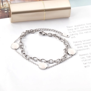 Detail of double-layer stainless steel bracelet with white shell inlays and 18KGP tag