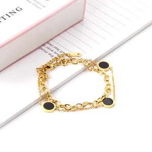 Detail of double-layer 18K gold plated bracelet with black enamel charms and lobster clasp