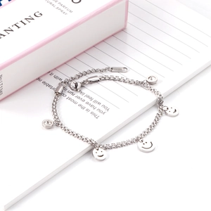 Detailed macro view of silver double-layer stainless steel bracelet with smiley pendants