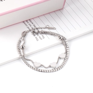 Detailed shot of double-layer stainless steel bracelet with heart charms and beads