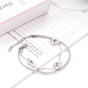 Close-up of double-layer stainless steel bracelet with Roman numeral rings and lobster clasp