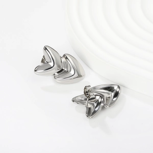 Detailed macro view of silver layered heart-shaped stud earrings with high-polished finish