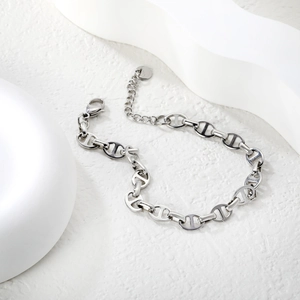 Macro view of silver stainless steel pig nose link bracelet with lobster clasp and chain