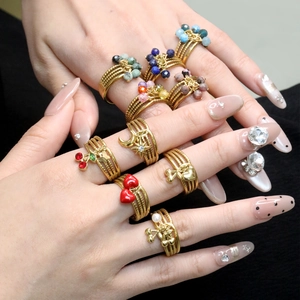 Gold multi-layer open rings with cherry heart charms and pearls worn on hand