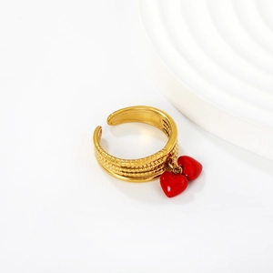 Detail of gold beaded adjustable ring featuring two red enamel heart tassel charms