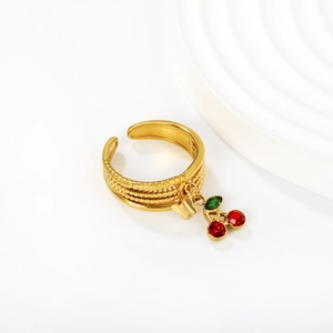 Macro shot of gold adjustable ring with cherry pendants and red zircon embellishments