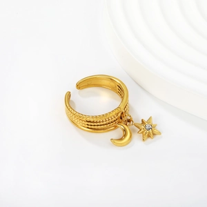 Detail of adjustable gold star and moon charms with zircon on a textured stainless steel ring