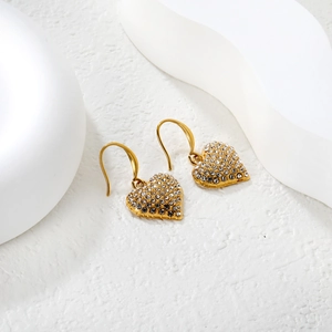 Détail de boucles d'oreilles cœur en acier doré 18K serties de cristaux scintillants