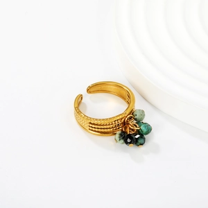 Detail of gold open ring with grainy texture and five dangling natural stone beads