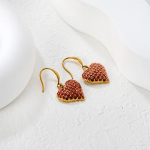 Boucles d'oreilles cœur plaquées or avec cristaux roses sur présentoir blanc épuré