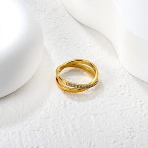 Crossed 18K gold-plated stainless steel ring with micro-pave crystals on white background