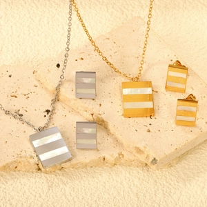 Détail de parures de bijoux en acier inoxydable avec incrustations de nacre blanche