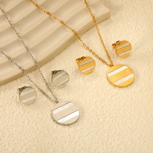 Détail de parure de bijoux géométrique avec incrustation de nacre blanche et boucles d'oreilles