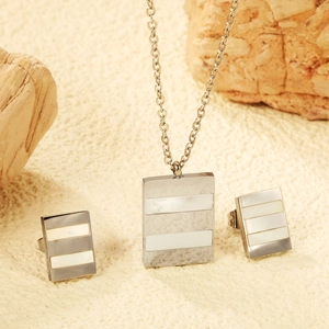 Gros plan d'un ensemble collier et boucles d'oreilles argenté avec incrustations nacre