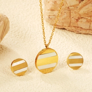 Détail du collier et des boucles d'oreilles en acier doré avec incrustation de nacre