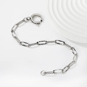 Detailed macro view of silver steel chain bracelet with textured links and spring clasp