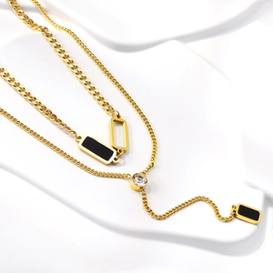 Detail of 18K gold double layer necklace with black rectangular charms and zircon