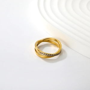 Macro detail of gold double-layer crisscross ring with micro-paved sparkling crystals