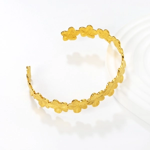 Eleganter goldener Edelstahl-Armreif mit aufwendig geschnitzten Blumenmustern
