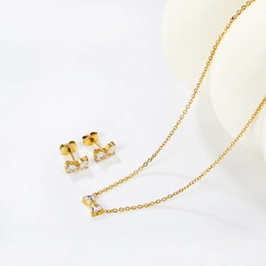 Detailansicht des goldenen Schleifen-Schmucksets mit funkelnden Zirkonia auf Weiß