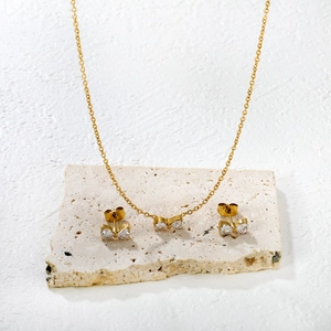 Elegantes goldenes Schmuckset mit Schleifen und weißen Kristallen, Halskette und Ohrringe