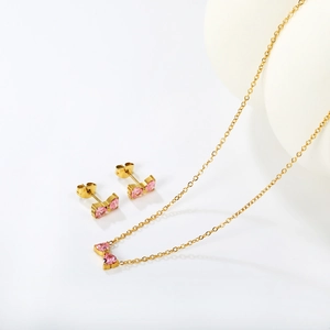 Detail von Schleife Halskette und Ohrringen mit rosa Herzsteinen und Gold-Finish