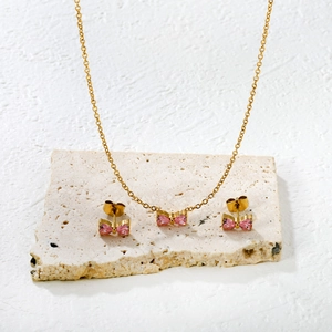 Elegantes vergoldetes Edelstahlschmuckset mit rosa herzförmigen Kristallen und Bogen