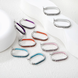Detailed view of oval hoop earrings with colorful enamel and micro-pave crystals