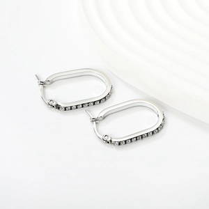 Detail of silver U-shaped oval hoop earrings with sparkling white cubic zirconia pavé