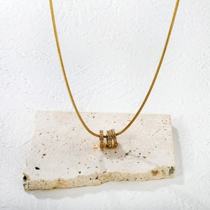 Luxueux collier chaîne serpent dorée avec trois anneaux sertis de cristaux brillants