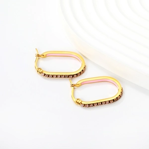 Detail of gold oval hoop earrings with pink enamel inlay and sparkling crystals