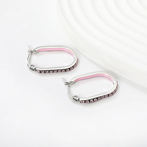 Close-up of oval stainless steel earrings with pink enamel and sparkling pavé crystals