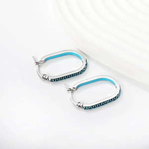 Detail of silver U-shaped hoop earrings with blue crystal inlay and enamel coating
