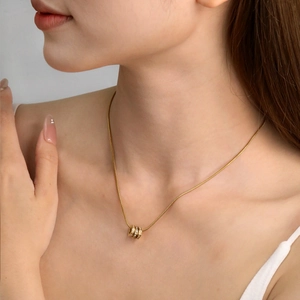 Collier élégant en acier plaqué or avec trois anneaux sertis de cristaux sur chaîne serpent