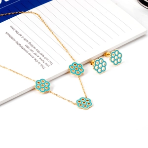 Golden stainless steel jewelry set featuring light blue enamel daisy necklace and earrings