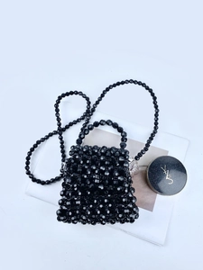 Handmade black beaded crossbody bag with handle and strap on white background