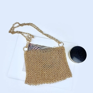 Detail of gold metal mesh chain crossbody bag with handwoven sequin pattern and strap