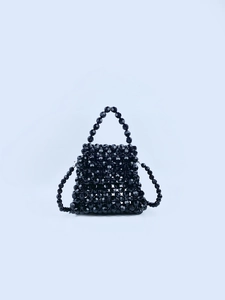 Detail of a handmade black beaded handbag with reflective faceted texture and woven beads