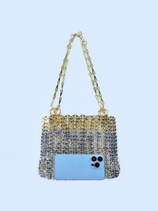 Macro detail of silver and gold woven metal evening bag with size reference phone