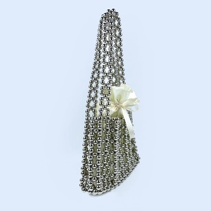 Close-up of silver beaded handbag featuring a glossy white satin drawstring inner pouch