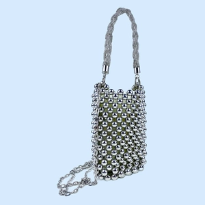 Detail of silver beaded handbag with metallic beads, green lining and chain strap